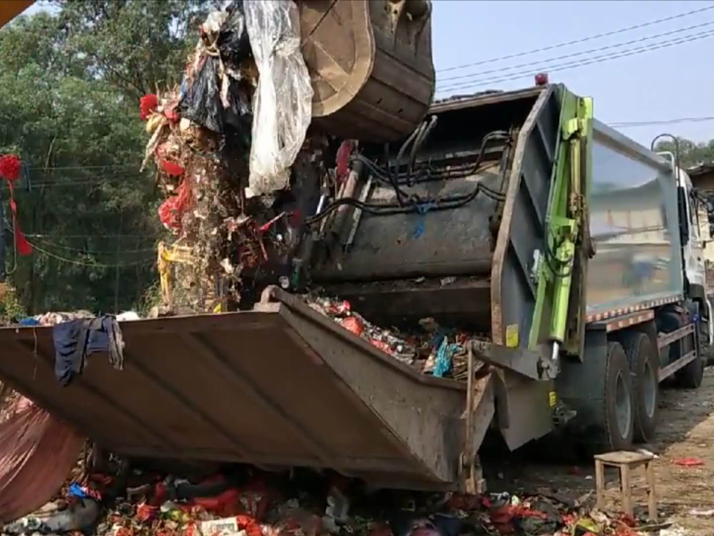 压缩垃圾车用挖机装料视频